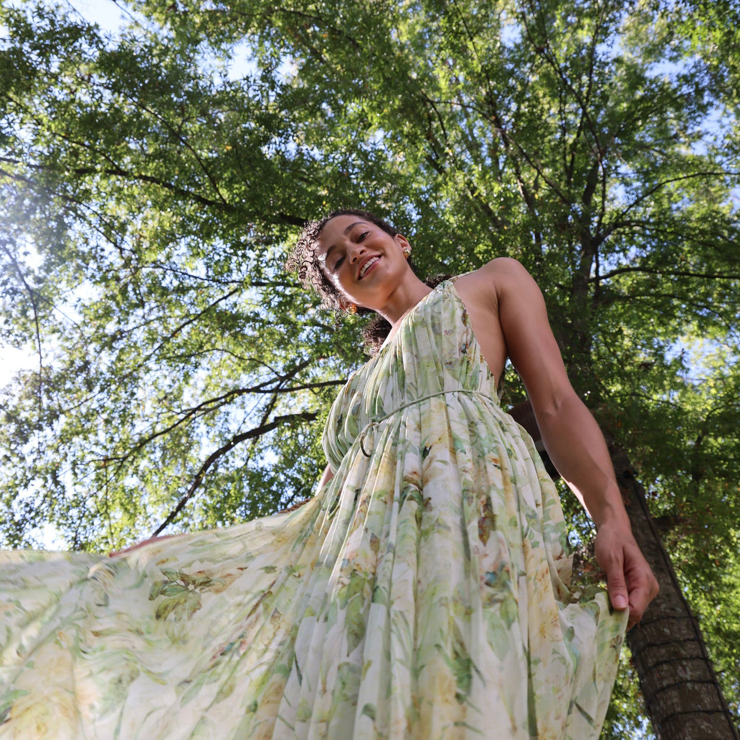 Woman in a floral dress standing among trees