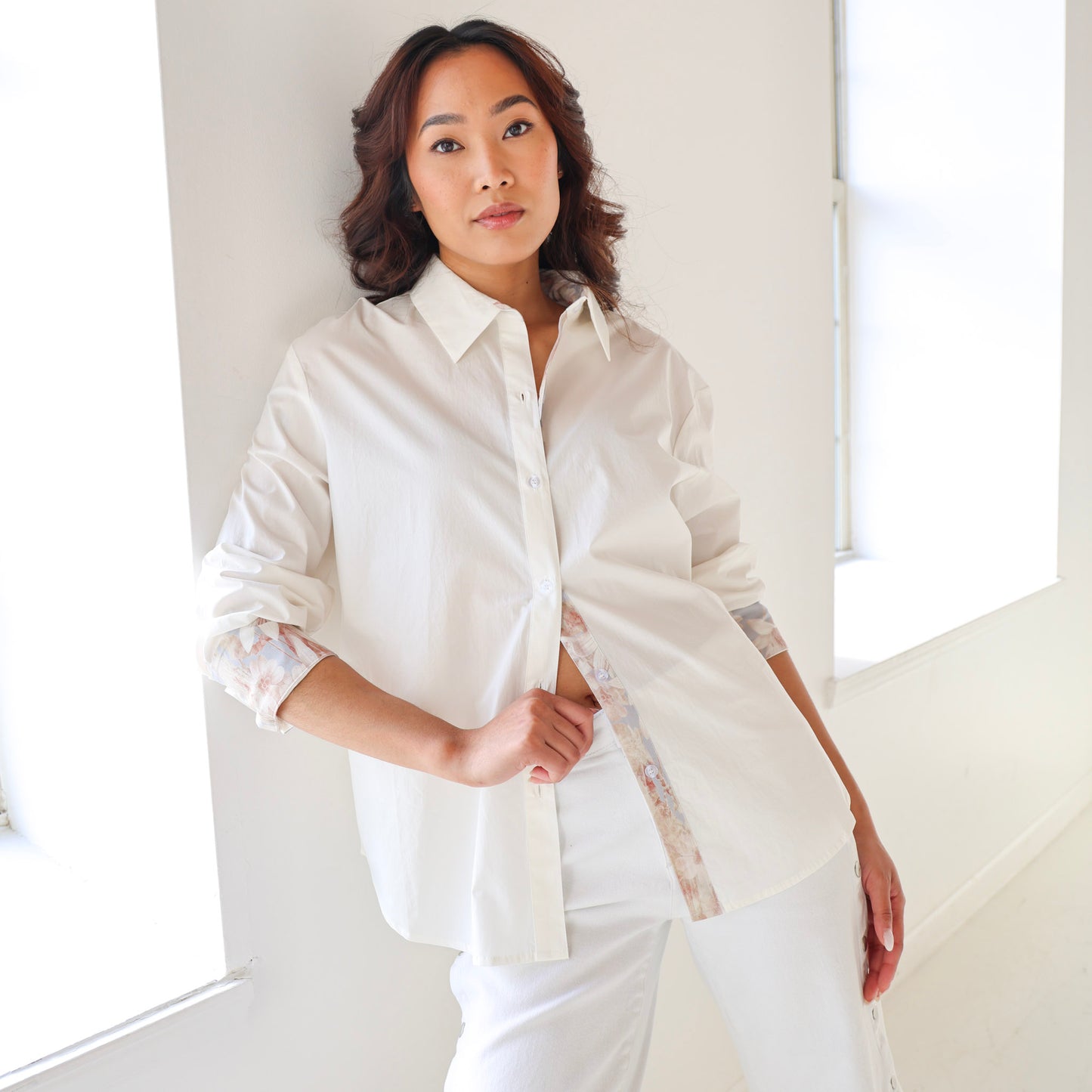 Woman wearing a white shirt and pants in a bright room