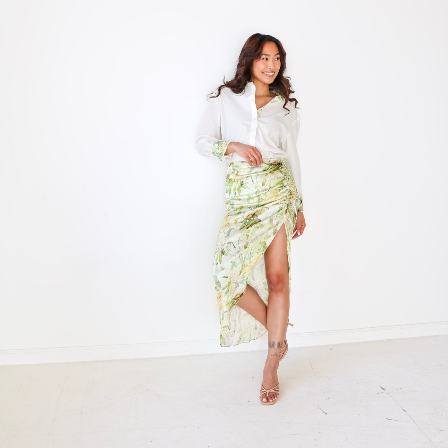 Woman wearing a white blouse and floral skirt on a white background