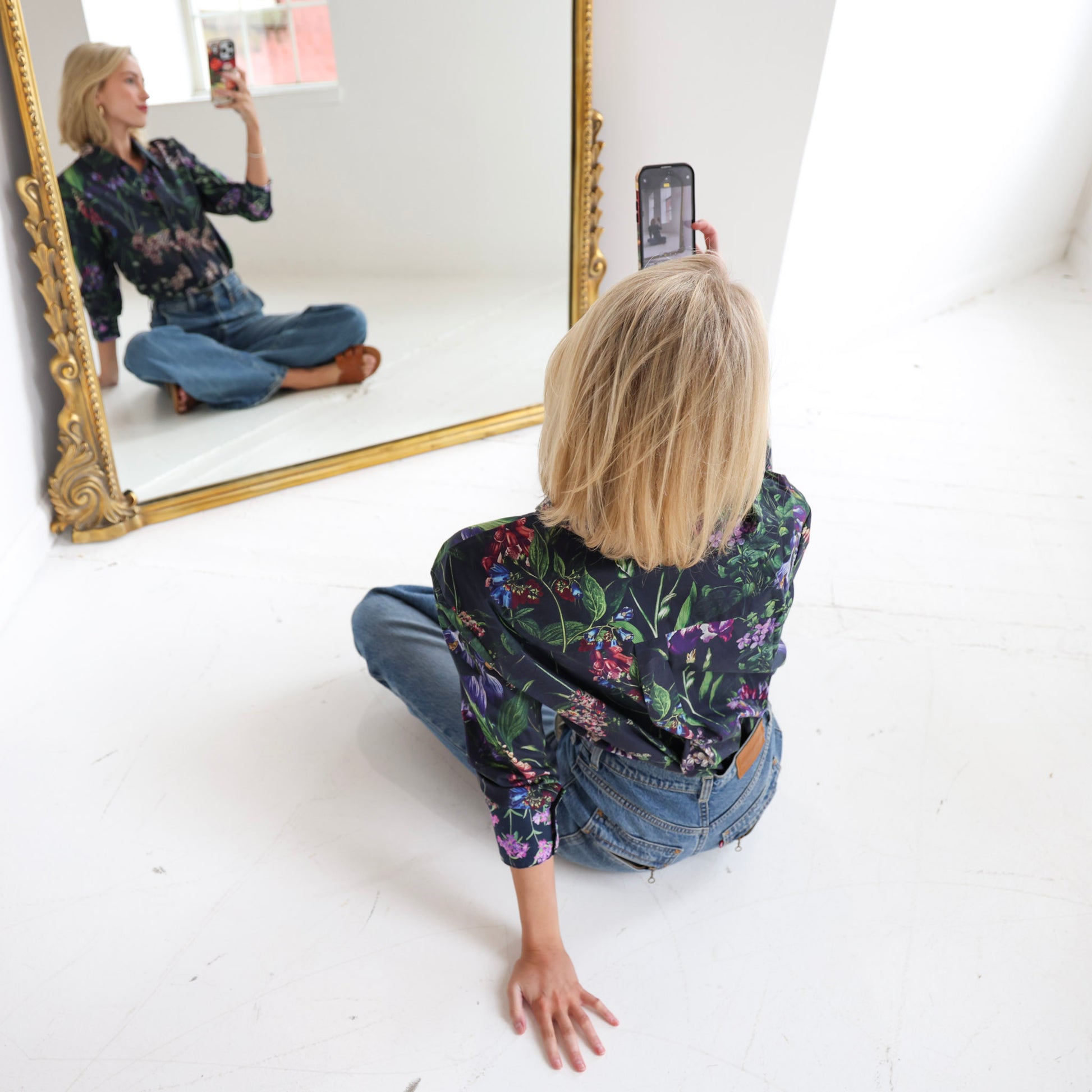woman wearing floral shirt taking selfie